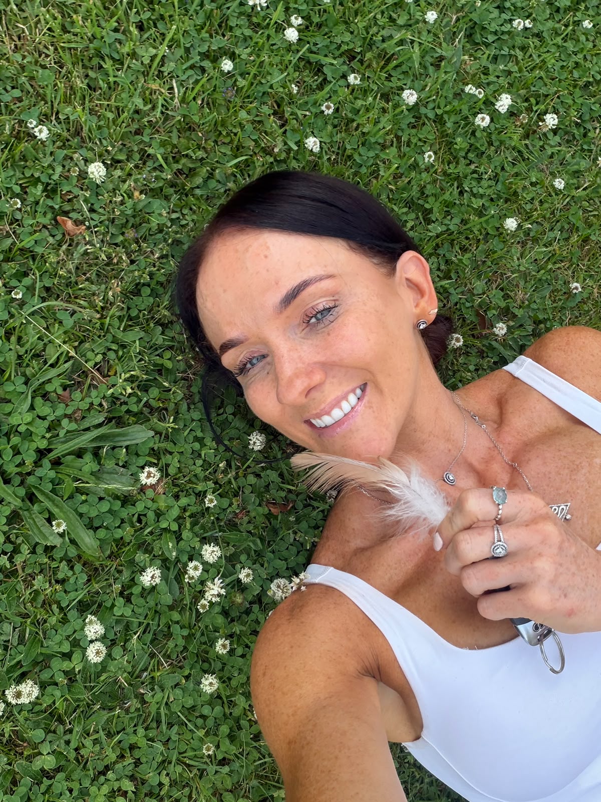 Michelle leaning against a large tree in a natural setting, embodying the Wild & Raw essence.